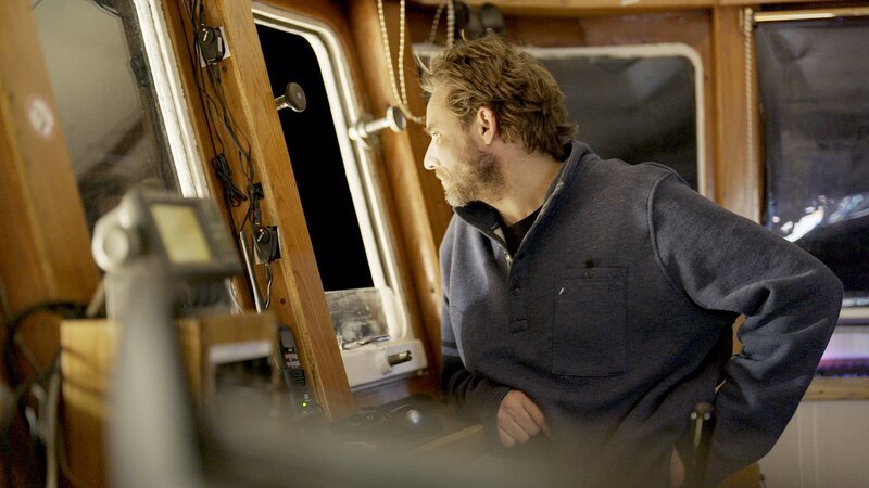 Jake Anderson im Steuerhaus mit Blick aus dem Fenster – Bild: Warner Bros. Discovery, Inc.
