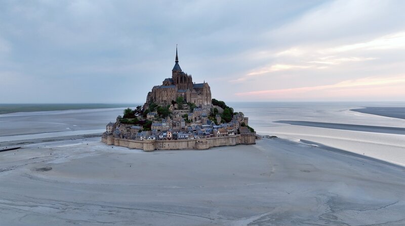 Mont-Saint-Michelle: Wie eine Fata Morgana ragt die berühmte Klosterinsel aus dem Watt. – Bild: NDR/​Florian Melzer/​Nonfictionplanet
