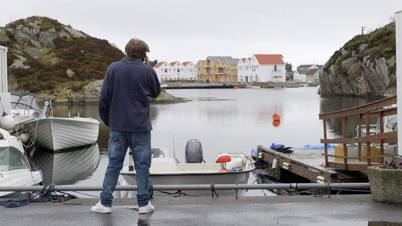 Jake telefoniert und schaut aufs Wasser hinaus. – Bild: Warner Bros. Discovery, Inc. or its subsidiaries and affiliates