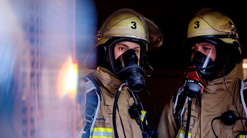 Zwei Feuerwehrmänner tragen Atemschutzmasken und Helme, die mit einer „3“ gekennzeichnet sind. Starke Verrauchung, Ursache unklar – Einsatz wegen eines Kaminbrands im Entstehungsstadium. – Bild: WDR/​Sebastian Drolshagen