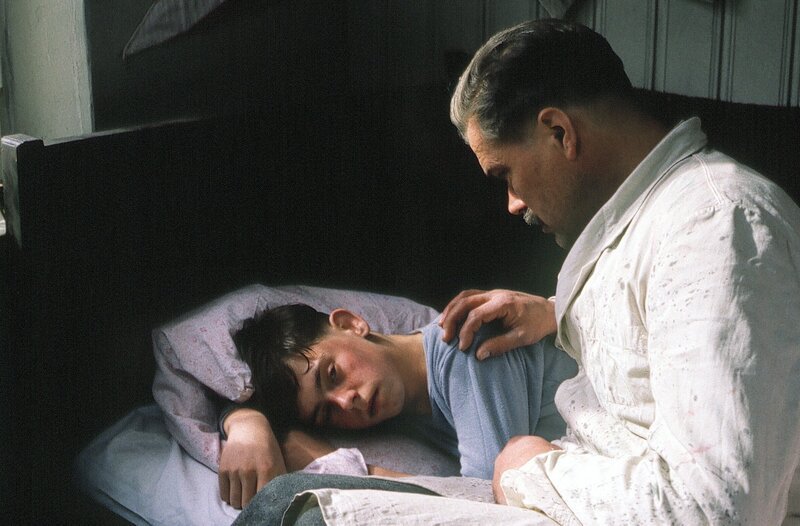 Hansi Hechselberger (Michael Netscher, links) liegt mit Fieber im Bett. Seinem besorgten Vater (Wolfram Kunkel) wird klar, dass seine Pistole, die unsachgemäß gelagert war, damit zu tun hat. – Bild: BR/​Tellux-Film GmbH /​ Sessner