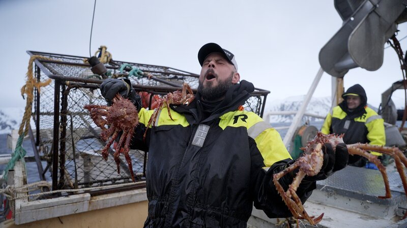 Mittlere Einstellung von Birgerson-Deckhelfer Ronnie, der eine Krabbe hält und feiert. – Bild: Warner Bros. Discovery, Inc. or its subsidiaries and affiliates