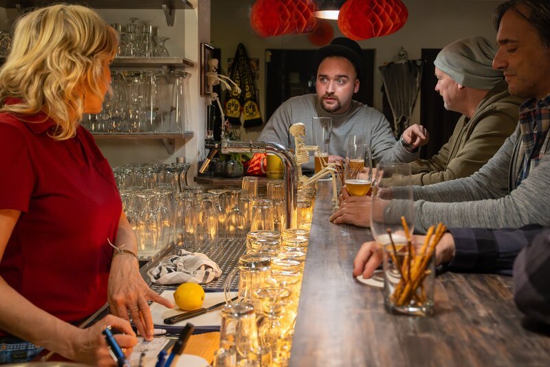 Alltag in einer Kneipe. Mehrere Gäste führen an einer Theke Gespräche über alles Mögliche. Auf einmal eskaliert die Situation. Am Ende steht ein furchtbares Verbrechen. – Bild: SASKIA PAVEK /​ ZDF