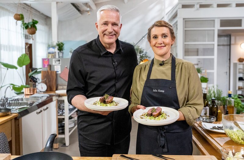 In der Sendung „Einfach & köstlich“ hat Alexander Herrmann für seinen Gast Julia Komp eine knusprig-rosa Entenbrust gegrillt, mit Rosmarin-Honig lackiert und einen Spitzkohlsalat dazu serviert. – Bild: BR/​2Bild TV.Events & Media GmbH/​Daniel Bechthold
