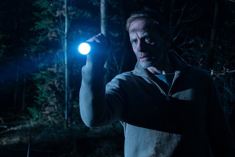Kai Hoffmann (Julian Weigend) sucht im dunklen Wald seinen kleinen Sohn Emil. – Bild: MDR/​Saxonia Media/​Sebastian Kiss