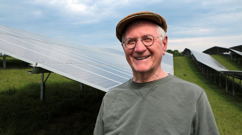 Hans Well im Porträt mit PV Anlage im Hintergrund. – Bild: BR/​Stefan Panzner
