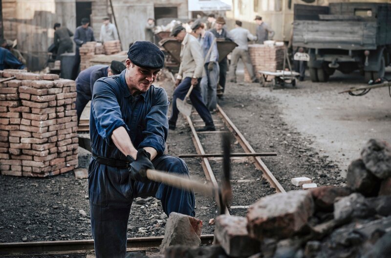 Tommy (David Schütter) hackt Steine auf der Baustelle an der Stalinalle – Bild: WDR/​UFA Fiction/​Willi Weber
