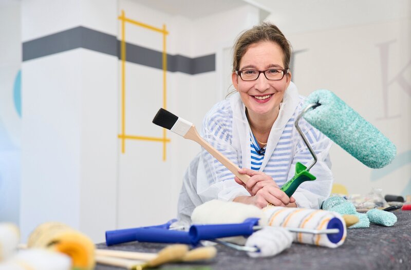 Hauswirtschaftsmeisterin Yvonne Willicks will wissen, wie tief man in den Geldbeutel greifen muss, um ein gutes Streichergebnis zu bekommen. Worauf sollte man beim Farbenkauf achten? – Bild: WDR/​solis TV/​Claus Langer
