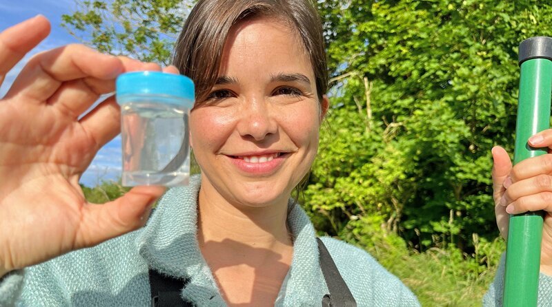 Stolz zeigt Anna den wilden Medizinischen Blutegel, den sie gefunden hat. Diese spezielle Blutegel-Art ist in Deutschland mittlerweile sehr selten und deswegen streng geschützt. – Bild: BR/​Text und Bild Medienproduktion GmbH & Co. KG/​Katharina Brackmann