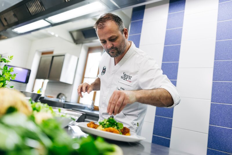 Fritz Grampelhuber kocht während des ServusTV-Drehs der Heimatküche beim Steegwirt in Bad Goisern am Hallstättersee, Österreich am 24.Juni 2025 – Bild: ServusTV /​ Johannes Jank /​ www.redbullmediahouse.com