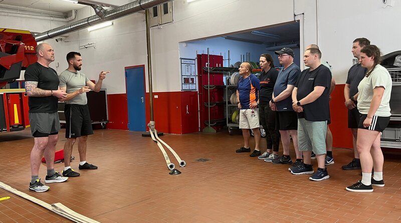 Mit Doc Esser (l) und Sportcoach Marwin Isenberg (2.v.l.) wird es sportlich für dieses Team der Freiwilligen Feuerwehr aus Radevormwald. – Bild: WDR/​solis TV