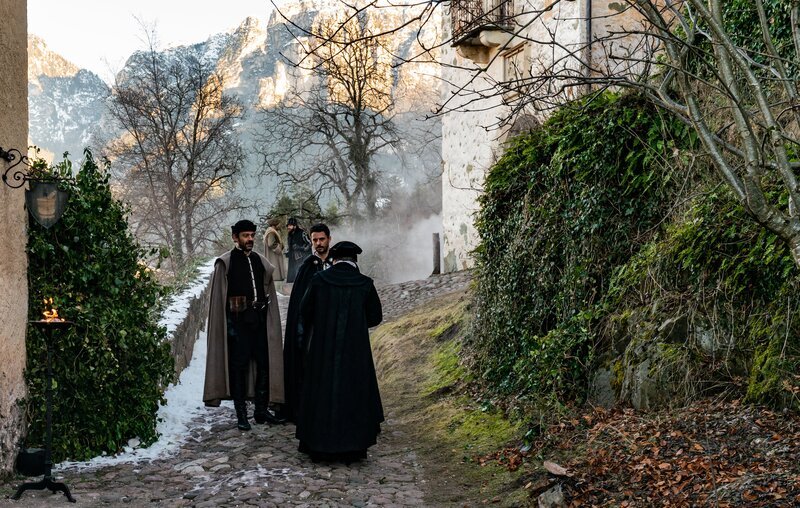 Matthew and Diana arrive in Bohemia to search for Edward Kelley and the Book of Life, which they believe to be in his possession. They meet Emperor Rudolf II, who immediately expresses a lascivious interest in Diana; she uses his interest to get inside his fabled collection of magical artifacts in search of the Book of Life, but Gallowglass can only find chilling evidence of Rudolf’s morbid fascination with creatures. Matthew’s protective jealousy causes problems as he and Diana are invited on a grouse hunt: pushed to the edge by the Emperor’s advances, Matthew sets his bird on Rudolf’s and inflames the Emperor’s wrath. At dinner, Diana chooses to reveal her power to Rudolph when provoked by the manner in which Rudolf treats a Rabbi, and she magically animates a serpent. Knowing her power is exposed, Matthew, Diana and Gallowglass make a daring bid for the Book,and discover it in the hands of a raving Edward Kelley. He tears three pages out before they can steal it from him and flee, and Matthew realises that the Book is made from the skin of creatures. In the present day, Knox arrives at the Emperor’s lodge, and sees evidence that the Book was once there; he is getting closer.bird on Rudolf’s and inflames the Emperor’s wrath. At dinner, Diana chooses to reveal her power to Rudolph when provoked by the manner in which Rudolf treats a Rabbi, and she magically animates a serpent. Knowing her power is exposed, Matthew, Diana and Gallowglass make a daring bid for the Book, and discover it in the hands of a raving Edward Kelley. He tears three pages out before they can steal it from him and flee, and Matthew realises that the Book is made from the skin of creatures. In the present day, Knox arrives at the Emperor’s lodge, and sees evidence that the Book was once there; he is getting closer. – Bild: Sky UK /​ ©Sky UK Ltd /​ Sky UK /​ ©Sky UK Ltd