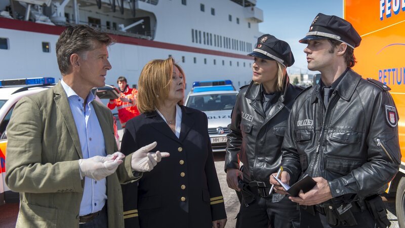 Melanie (Sanna Englund, 2.v.r.) und Mattes (Matthias Schloo, r.) beim Einsatz am Hamburger Hafen. Wolf Sander (Nick Wilder, l.), der Chefarzt des Traumschiffs, wurde von einem unzufriedenen Passagier geschlagen, als er Chefhostess Beatrice (Heide Keller, 2.v.l.) zur Hilfe kam. – Bild: ZDF und Boris Laewen