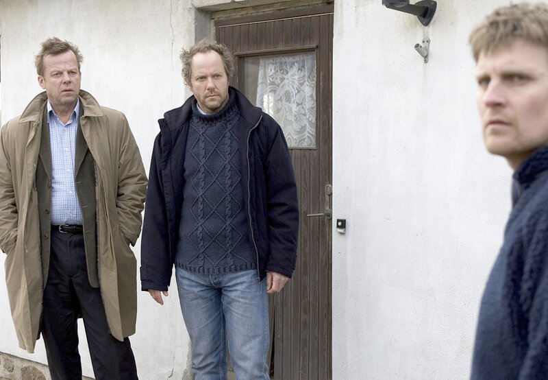 Kommissar Kurt Wallander (Krister Henriksson, links) und sein Kollege Martinsson (Douglas Johansson, Mitte) verdächtigen den Schul-Hausmeister (Stefan Gödicke). – Bild: WDR/​Degeto/​Lars Høgsted