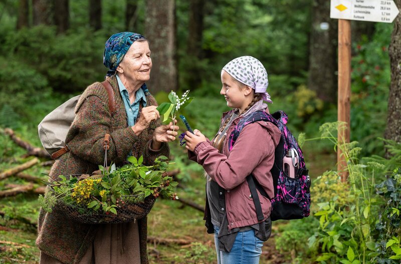 Carlotta (Mila Breiter) ist mit Lioba (Lisbeth Felder) auf Kräutersuche im Wald unterwegs und hat keinen Handy-Empfang. – Bild: SWR/​Patricia Neligan
