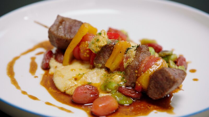 Auf dem Speiseplan von Frank Buchholz steht ein typisch italienisches Gericht, das hierzulande nicht so bekannt ist: gegrillte Spieße vom Lammfilet mit selbst getrockneten Kirschtomaten, Dicken Bohnen und cremig gerührter Polenta. – Bild: WDR/​2Bild GmbH