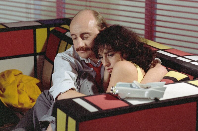 Bernard (Michel Blanc) tröstet seine Nachbarin Nadine (Anémone), die kurz vor einem Nervenzusammenbruch steht. Auch sie versucht, mit einer schmerzhaften Trennung klarzukommen. – Bild: Studiocanal