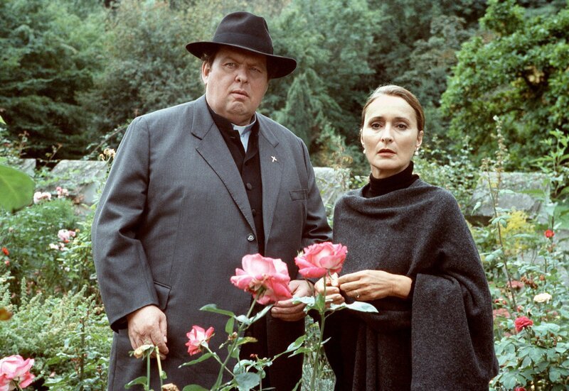 Baronin Lydia (Elenore Weisgerber) zeigt Pfarrer Braun (Ottfried Fischer) ihre Lieblingsrosen. – Bild: BR/​ARD Degeto/​Andrea Enderlein