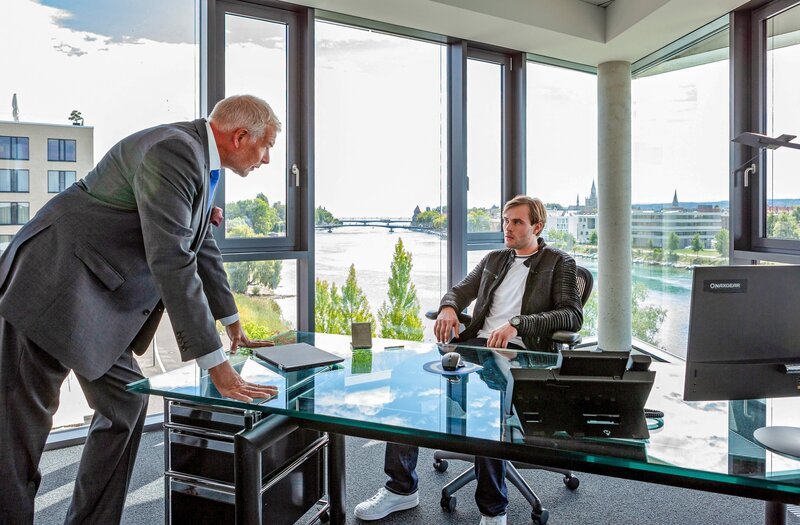 Der Bauunternehmer Manfred Treskow (Frank Vockroth, l.) betreut seinen Sohn Ben (Christopher Reinhardt, r.) mit dem Projekt – er soll der Witwe Dellbrück das Seegrundstück abpressen. – Bild: ORF/​Bavaria/​ARD/​SWR/​Daniel Schmid