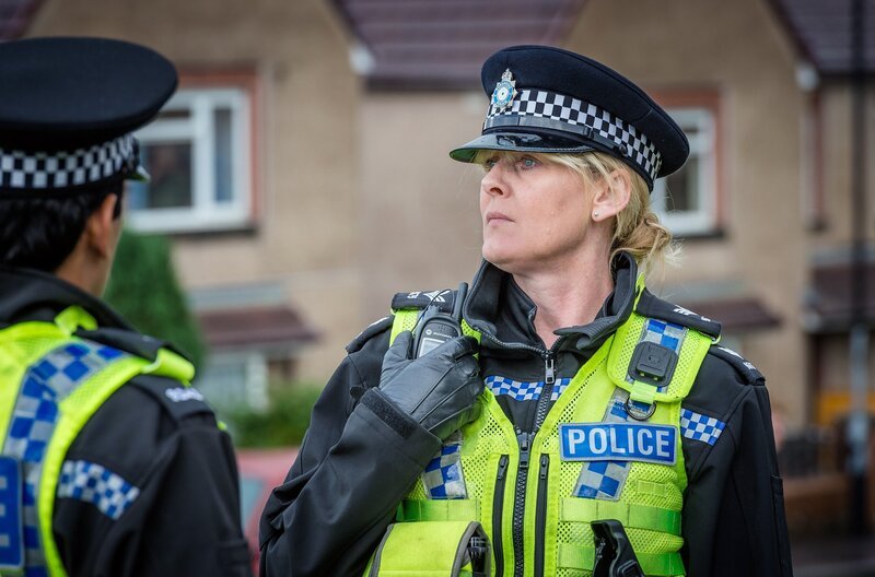 Zurück im Berufsalltag macht Catherine (Sarah Lancashire, re.) direkt eine grausige Entdeckung: Tommys Mutter wurde erwürgt. Da auf dem Anrufbeantworter der Toten Drohnachrichten von Catherine gefunden wurden, gerät sie selbst unter Verdacht. – Bild: Ben Blackall/​Red Production Company