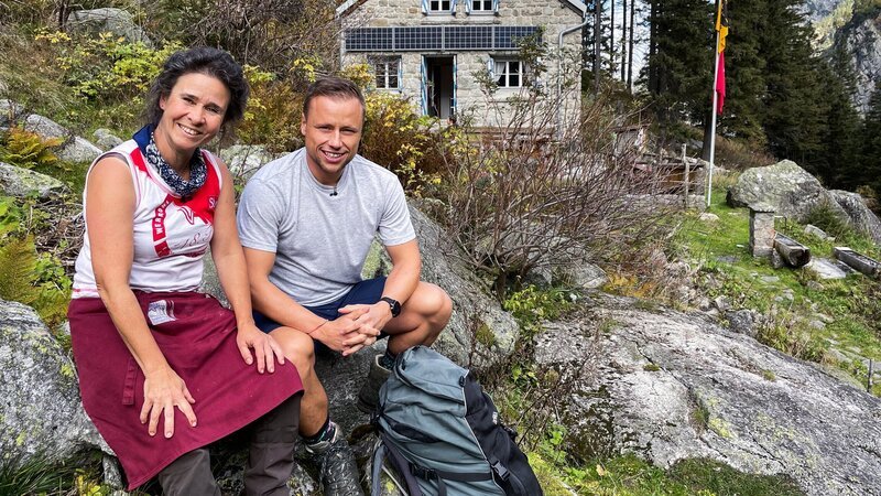 Jan Fitze vor der Treschhütte mit Hüttenwartin Franziska Kunz-Waser – Bild: SRF