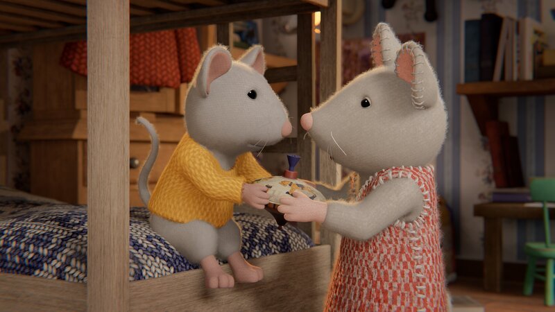 Ben (l.) übergibt Julia (r.) seinen Spielzeugkreisel. Damit will er an der Spielzeug-Lotterie teilnehmen, die Julia heute im Mäusehaus veranstaltet. – Bild: Cielo Films – Caribara Production /​ ZDF /​ SuperswissRed