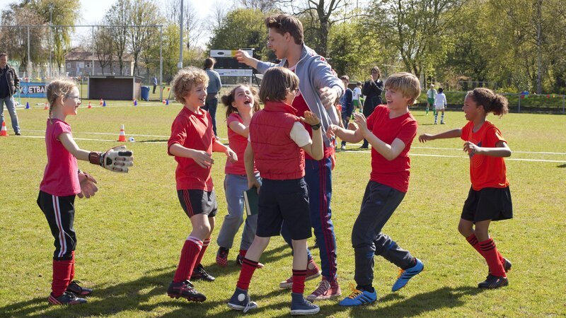 Herr Kees (Leendert de Ridder, M.) und sein Fußballteam der Klasse 6b bejubeln ihren Sieg. – Bild: ZDF/​Victor Arnolds