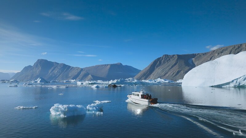 Das Teamboot auf offener See, umgeben von Eisbergen. – Bild: Courtesy of Disney+ /​ National Geographic/​Pablo Durana