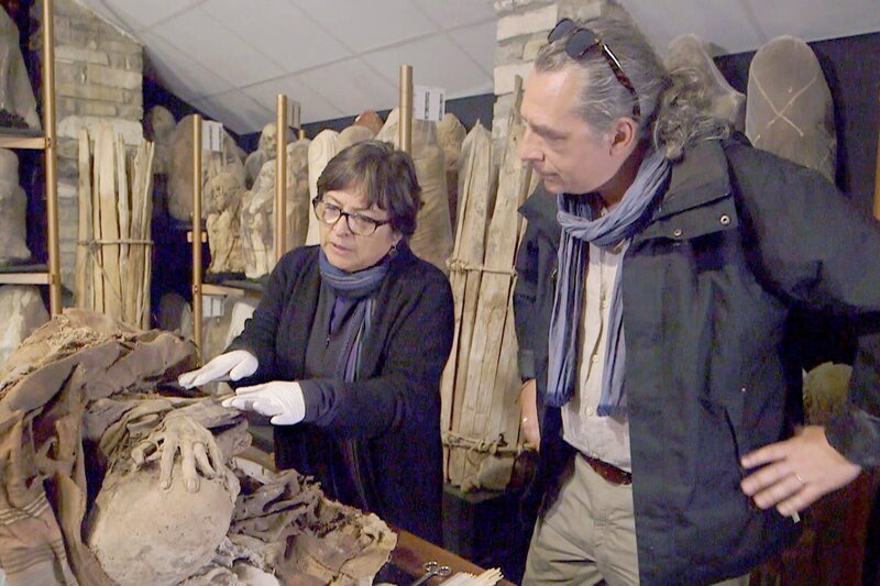 Die peruanische Archäologin Sonia Guillén zeigt Peter Eeckhout eine der über 200 außerordentlich gut erhaltenen Mumien, die 1997 in mehreren Mausoleen nahe des Kondorsees entdeckt wurden und heute im Museum von Leymebamba aufbewahrt werden. – Bild: Tournez S’il Vous Plaît Production