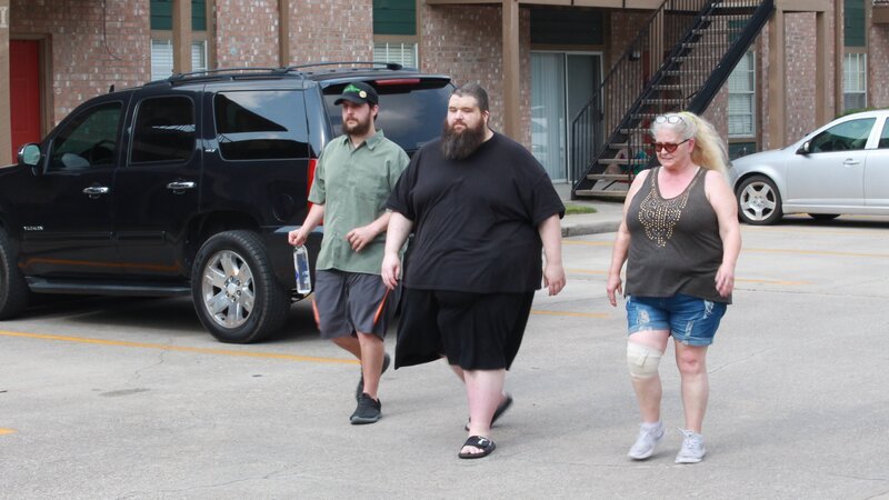 Chris (m.) walking with family outside apartment – Bild: Warner Bros. Discovery, Inc. or its subsidiaries and affiliates
