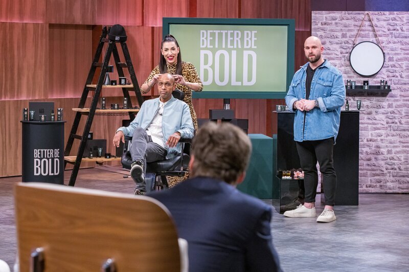 Moderator Amiaz Habtu unterstützt die Gründer von „Better Be Bold“ bei ihrem Pitch als Model. Investorin Tijen Onaran unterzieht das natürliche Glatzenpflege-Produkt an ihm direkt dem Praxistest. Rechts Dennis Baltzer – einer der Gründer. – Bild: RTL