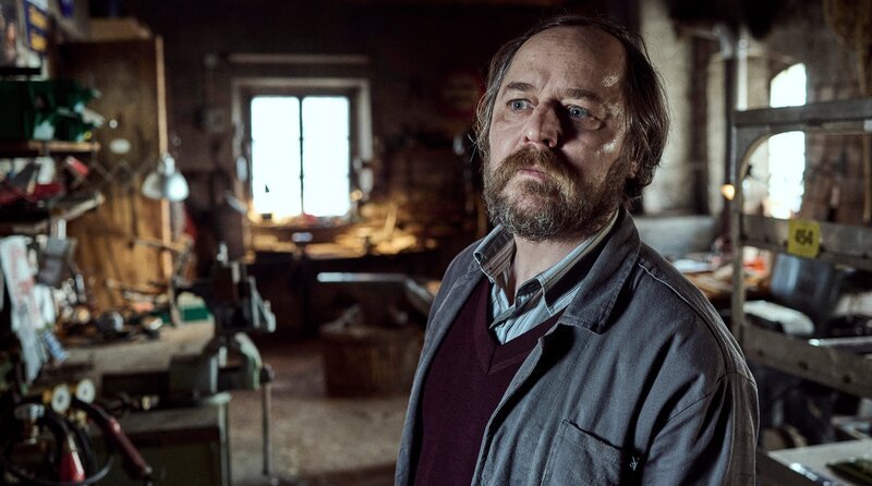 Hubert Höllrigl (Thomas Schmauser) in seiner Emaillierwerkstatt. – Bild: BR/​ARD Degeto/​Hager Moss/​Bernd S