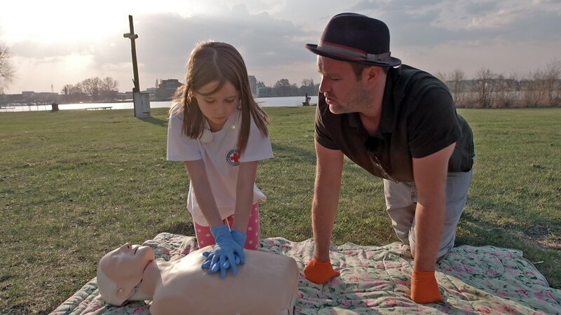 Lina ist Erst-Helferin bei der Wasserwacht. Sie zeigt KiKA-Moderator Ben wie Erste-Hilfe geleistet wird. – Bild: MDR/​Cine Impuls