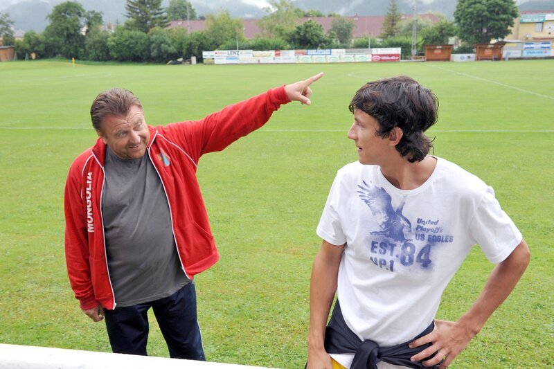 „FC Rückpass“, „Viertelfinale.“ Das erste Spiel des FC-Pernitz unter Führung von Kovacic gerät zum Desaster. Die Mannschaft hat sich vollzählig gegen den ungeliebten „Neuen“, Roland Preissler, verschworen und lässt den Stürmer ohne Ball verhungern. Kovacic wechselt ihn aus, da geht plötzlich auch noch das Licht an den Fluchtlichtmasten aus. Schurbitz muss sich ab sofort auch noch mit einer drohenden Platzsperre auseinandersetzen. Abseits des Spielfelds lerne Ilse Drabusch und Uschi einander besser kennen, da Uschi bei Ilse in der Kantine aushilft. Die beiden Frauen haben ein gemeinsames Thema: Männer im Allgemeinen, Rainer Kovacic im Speziellen. Natürlich intrigiert der frühere Trainer Hopfberger weiter. Er will den Präsidiums- und Vorstandsvorsitzenden Fadinger auf seine Seite bringen, um doch noch Präsident werden zu können. Doch Fadinger spielt sein eigenes Spiel. Das ihm beinahe das Leben kostet. Im Bild (v.li.): Lukas Resetarits (Rainer Kovacic), Laurence Rupp (Roland Preissler). – Bild: ORF/​Gebhardt