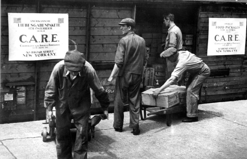 Männer verladen Carepakete. – Bild: ORF/​ORF III/​CARE