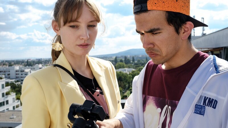 Dani (Julia Roy) zeigt Flo (Bagher Ahmadi) ihre Kamera mit der sie ihre Online-Geschichten filmt. – Bild: ZDF