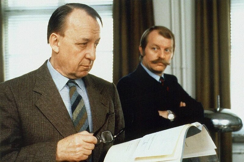 Kriminalkommissar Thanner (Eberhard Feik, l) wartet auf die Meinung seines Chefs Karl Königsberg (Ulrich Matschoss) in der Mordsache Petschek. – Bild: WDR