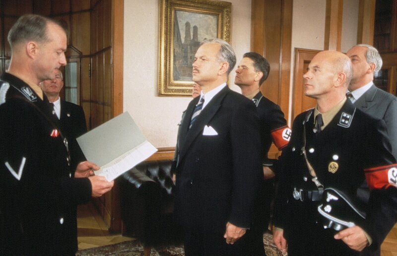 Karl Grandauer (Jörg Hube) wird endlich zum Oberkommissar befördert. – Bild: BR/​Tellux-Film GmbH