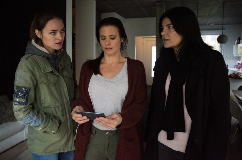 Claudia (Elisabeth Baulitz, M.) zeigt Lucy (Josephin Busch, l.) und Mina (Jasmin Tabatabai, r.) das erschreckende Video, das sie von ihrer Tochter Lena erhalten hat. – Bild: ZDF und Oliver Feist