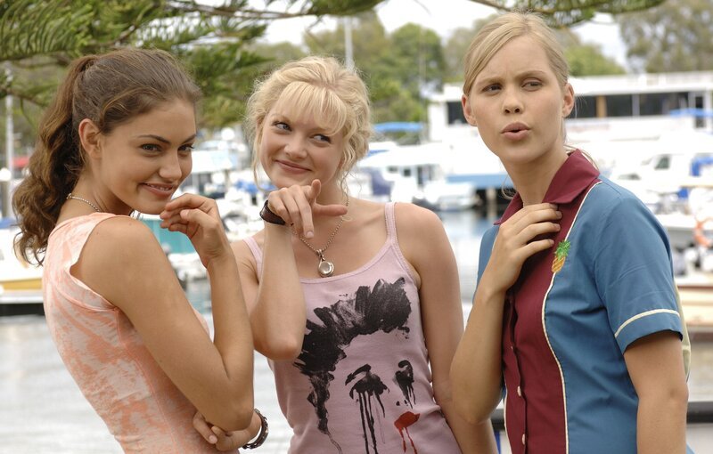 Der Angeber Nate hat sich mit einer geheimnisvollen Tinktur besprüht, die eine magische Anziehungskraft auf die Meerjungfrauen ausübt. Die Mädchen (v.l.n.r.: Cleo: Phoebe Tonkin, Rikki: Cariba Heine und Emma: Claire Holt) sind pöštzlich ganz vernarrt in ihn. – Bild: ZDF/​Jasin Boland