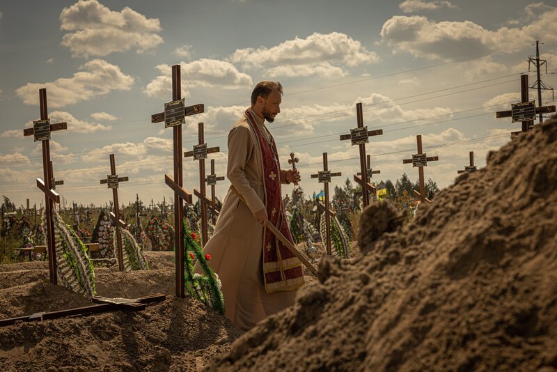 Ein Priester bestattet die ukrainischen Zivilisten, die 2022 von russischen Soldaten in Butscha ermordet wurden. – Bild: ZDF und Getty Images
