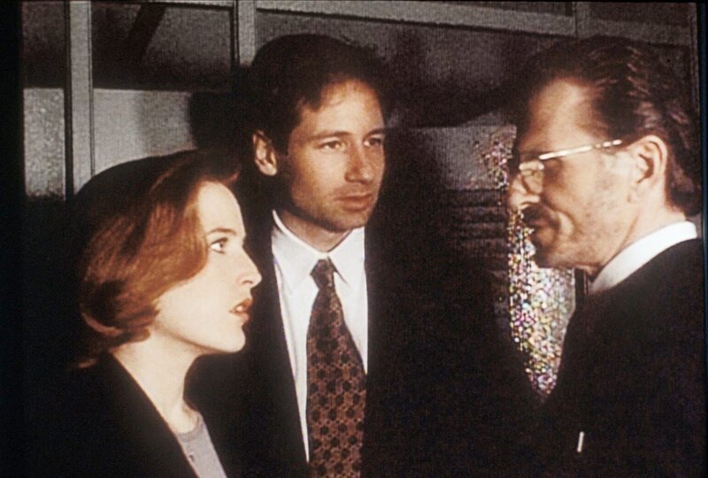 Scully (Gillian Anderson, l.) und Mulder (David Duchovny, M.) erfahren vom Nachtwächter des Bostoner Museums für Naturgeschichte, dass mehrere Forscher, die mit der sagenhaften Amaru-Urne zu tun hatten, inzwischen tot sind. – Bild: ProSieben MAXX