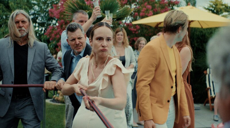 Das Charity-Event im eigenen Garten verwandelt sich zwischen Befürwortern und Gegnern des Pools in ein erbittertes Tauziehen um die Deutungshoheit über das Wasser (Sophie Arbeiter – links, Hendrik Heutmann – Mitte, Claudio Caiolo – rechts). – Bild: SWR/​Filmakademie Baden-Württemberg