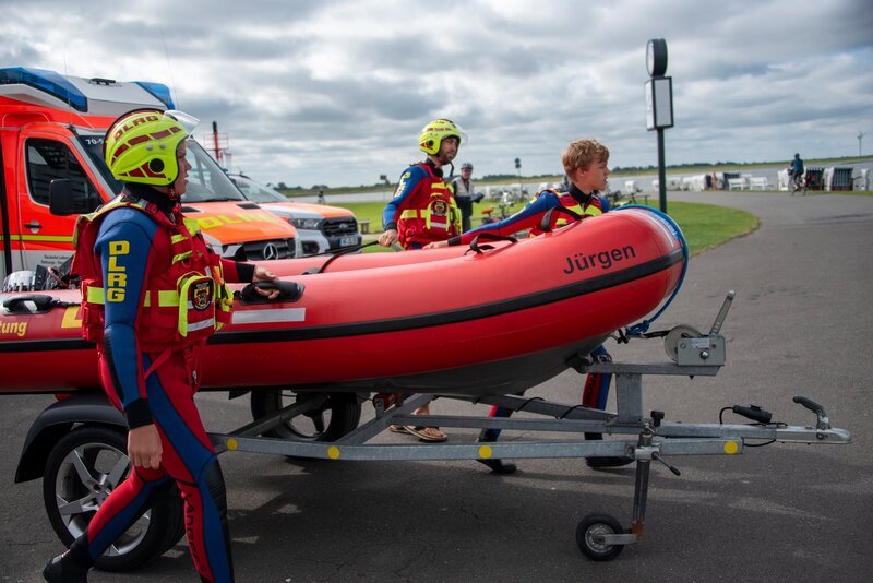 Janne bringt mit seinem Team das Schlauchboot ans Wasser. – Bild: NDR /​ Mingamedia