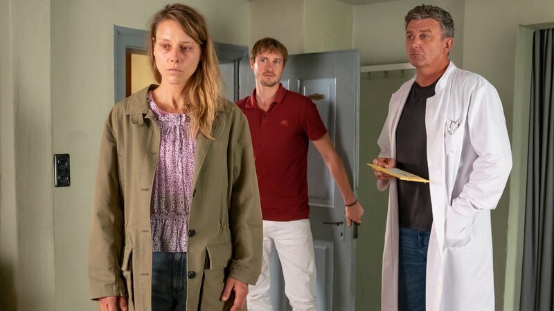 Tina Reichert (Xenia Tiling, l.) kann keine Hilfe von ihrem Bruder erwarten. Dr. Martin Gruber (Hans Sigl, r.) und David Ka?stner (Fre?de?ric Brossier, M.) wissen, dass dies ihr Todesurteil sein wird. – Bild: Erika Hauri