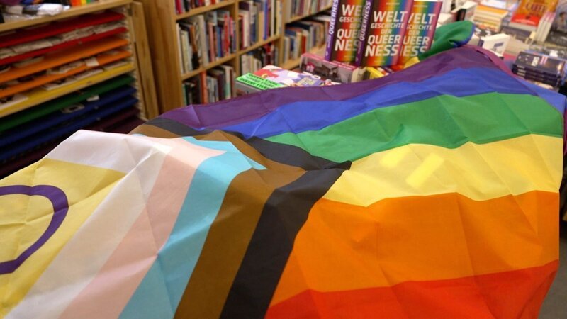 Pridefahne auf Büchertisch in Buchhandlung Löwenherz. – Bild: ORF/Landesstudio Wien Pridefahne auf Büchertisch in Buchhandlung Löwenherz. – Bild: ORF/Landesstudio Wien