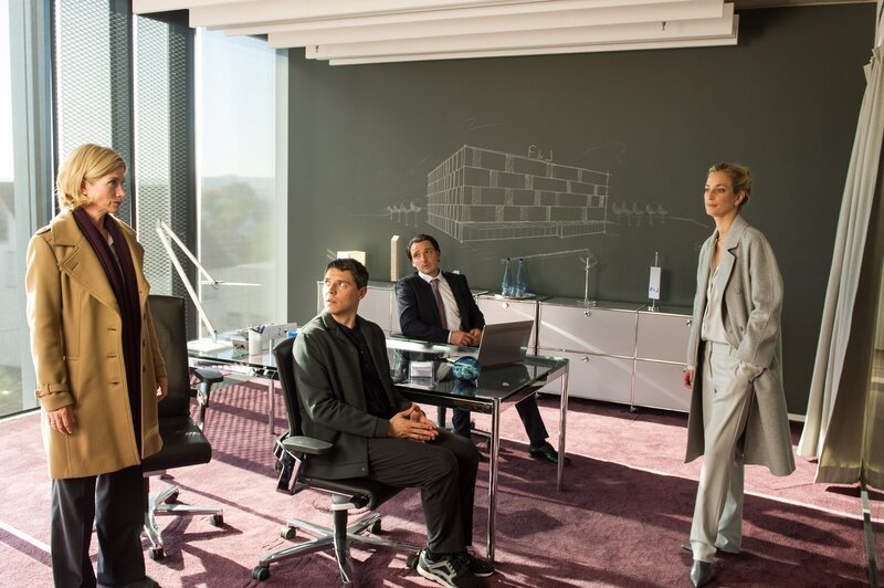 Martina Seiffert (Astrid M. Fünderich, l.) und Rico Sander (Benjamin Strecker, 2.v.l.) befragen Georg Jäger (Sascha Göpel, 2.v.r.) und seine Frau Theresa (Tina Bordihn, r.) im Büro seiner Baufirma. Henriette sollte mit ihrem Halbbruder 50 Prozent der Firma erben, nachdem ihr Vater starb. – Bild: MARKUS-FENCHEL /​ ZDF