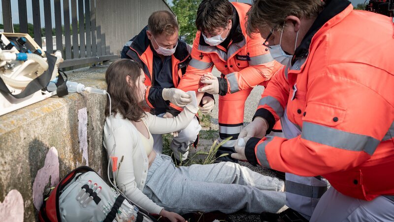 Haase ( Fabian Harloff, 2.v.l.) und seine Kollegen (Komparsen) leisten erste Hilfe bei einem Mädchen (Polina Schmal, l.), das halb bewusstlos von einem Arbeiter der Müllabfuhr gefunden wurde. – Bild: ZDF und Boris Laewen