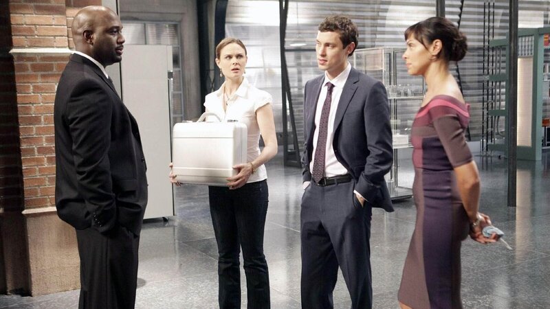 Brennan (Emily Deschanel, 2.v.l.), Sweets (John Francis Daley, 2.v.r.) und Cam (Tamara Taylor) werden von Mr. White (Richard T. Jones) und seiner geheimnisvollen Regierungstruppe im Institut festgehalten und beauftragt, die Todesursache einer streng geheimen, nicht identifizierten Leiche festzustellen. – Bild: TVNOW /​ FOX