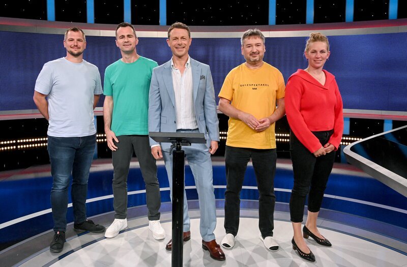 In der beliebten Radiowoche treten Radiomoderatorinnen und -moderatoren der ARD-Wellen gemeinsam mit ihren Hörerinnen und Hörern gegen die geballte Expertise der Quiz-Elite an. Moderator Alexander Bommes (M.) mit den Kandidat:innen (v.l.n.r.): Christian Recktenwald, Frank Falkenauer (SR 1), Christoph Paninka, Franziska Eder (Bayern 2). – Bild: ARD/​Uwe Ernst